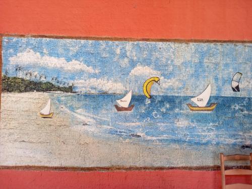 a painting of boats in the water on a wall at guesthouseparacuru in Paracuru