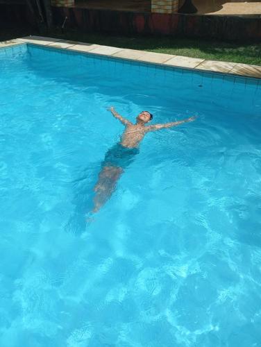 a man is swimming in a swimming pool at guesthouseparacuru in Paracuru