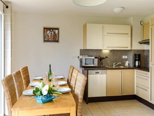 Il comprend une cuisine avec une table en bois et des chaises. dans l'établissement Maisonette near Mont Saint-Michel, à Cancale