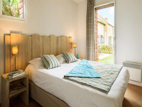 une chambre avec un grand lit avec une tête de lit en bois dans l'établissement Maisonette near Mont Saint-Michel, à Cancale