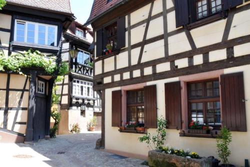 an old building with windows and flowers in a street at Ferienwohnung Sester in Gengenbach