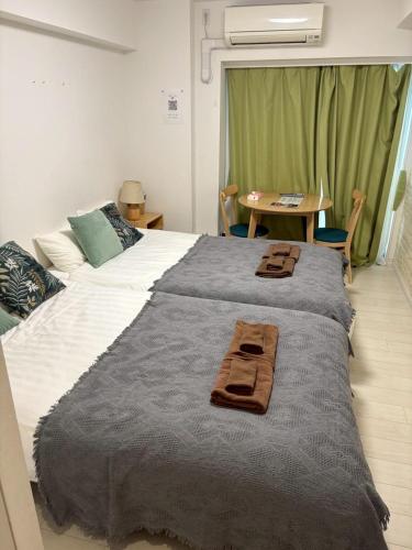 a bedroom with a large bed with towels on it at リブシティ錦糸町参番館上層階眺望良好北欧ルーム, Akihabara 6mins, Tokyo 8 mins, Direct to Narita Airport 成田空港直達 in Tokyo