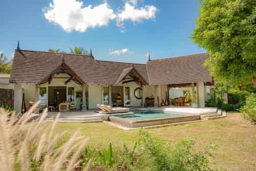 a house with a swimming pool in the yard at Maradiva Villas Resort and Spa in Flic-en-Flac