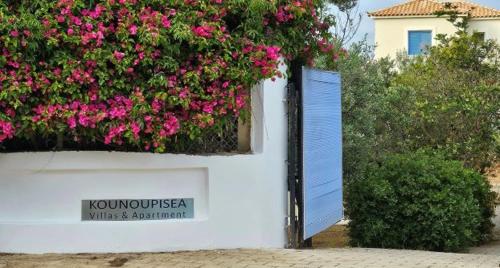 a white building with flowers on the side of it at Διαμέρισμα με υπέροχη θέα Porto Cheli Kounoupi in Porto Heli