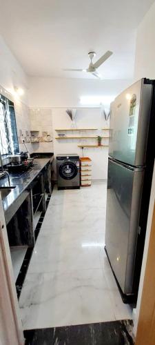 a large kitchen with a stainless steel refrigerator at Green House Stay in Mandrem