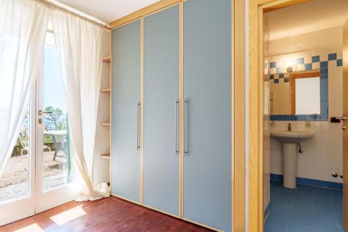 Un baño con muebles blancos y un lavabo. en Villa La Duna, en Marina di Castagneto Carducci