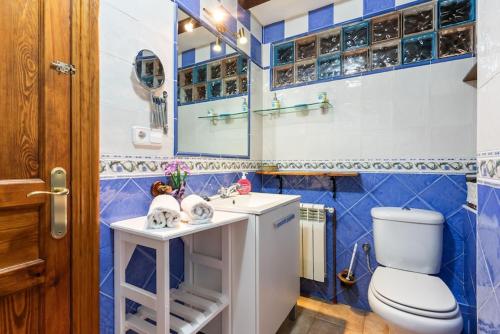 Un baño azul y blanco con inodoro y lavabo. en Casa El Campano, en Ontaneda