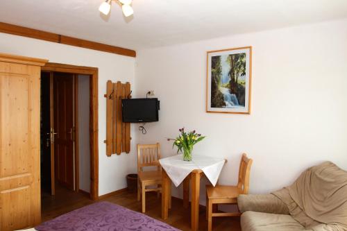 a living room with a table and a tv at Bauernhof Kasleitner in Zell am Moos