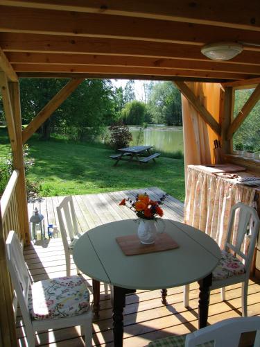 un patio avec une table et des chaises sur une terrasse dans l'établissement Peony Lodge - The Good Life in France, à La Chapelle-Thémer