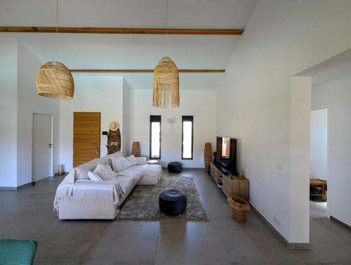 un salon avec un canapé blanc et une télévision dans l'établissement House with pool, à Lecci