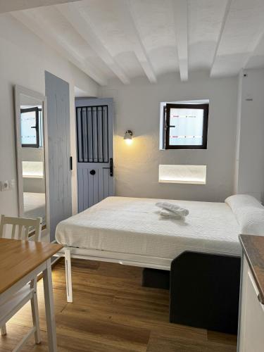 een witte kamer met een bed en een tafel bij Mazuelo - Harbor's Light in Villajoyosa