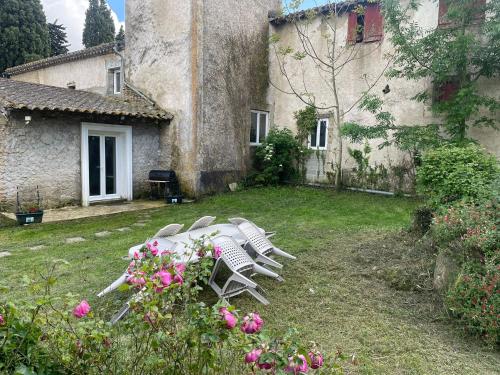 a group of chairs sitting in the yard of a building at les bambous in Mas-Saintes-Puelles