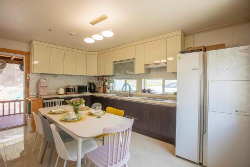 a kitchen with a table and a white refrigerator at Amuse 545 in Yangpyeong
