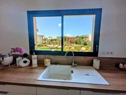 un comptoir de cuisine avec un évier et une fenêtre dans l'établissement House with pool, à Lecci