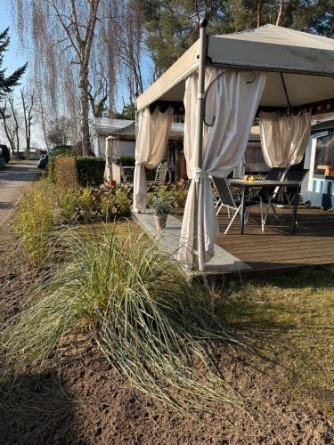 a gazebo with a table and chairs on a deck at La Pura Vida - Glamping in Brandenburg an der Havel