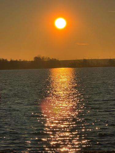 a sunset over a large body of water at La Pura Vida - Glamping in Brandenburg an der Havel