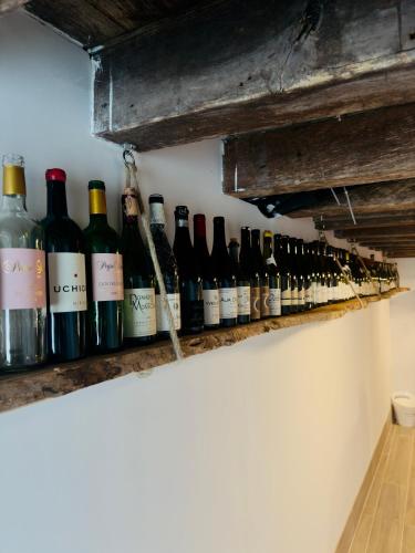 a row of wine bottles on a wall at Domaine Le Petit Moulin in Lachy