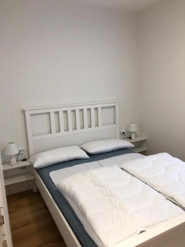 a white bed with two pillows in a bedroom at Villa Wetzel Domaso in Montemezzo