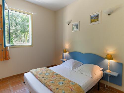 une chambre avec un lit avec deux lampes et une fenêtre dans l'établissement Maisonette in Gaujac near Village Center, à Gaujac