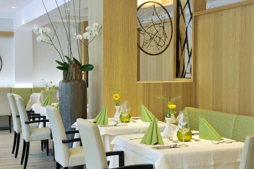 a dining room with white tables and white chairs at Hotel Annelies in Ramsau am Dachstein