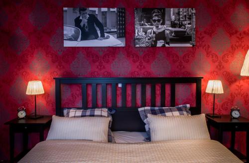 a bedroom with red walls and a bed with two lamps at Restaurace Stará Lípa in Česká Lípa