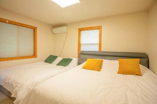 a bedroom with two beds with yellow and green pillows at Amuse 545 in Yangpyeong