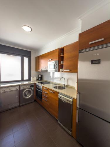 a kitchen with a stainless steel refrigerator and a dishwasher at Apartamentos Verdemar (VUT) in Llanes