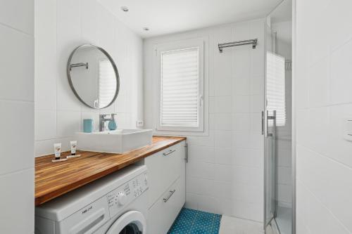 une salle de bain avec un lavabo et une machine à laver dans l'établissement Nice apartment in the heart of Paris by Weekome, à Paris