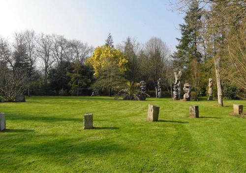 a field with a group of statues in a park at Gîte du jardin de pierre in Pléhédel