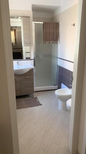 a bathroom with a sink and a toilet and a shower at Costa Verde Apartment in Buggerru