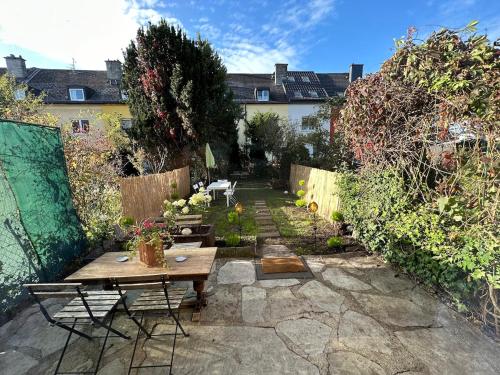 a patio with a table and chairs in a garden at Nest & Rest Garden Stay with Free Parking in Salzburg
