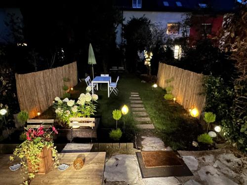 a garden at night with a table and flowers at Nest & Rest Garden Stay with Free Parking in Salzburg