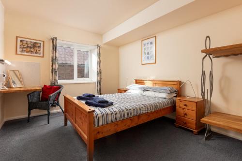 a bedroom with a bed and a desk and a chair at Discovery Accommodation in Whitby