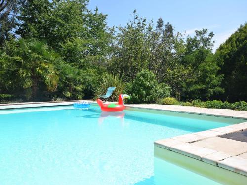 une piscine vide avec un radeau gonflable rouge et une piscine rouge dans l'établissement Lovely house with grass garden shared swimmingpool next to the river Ard che, à Lalevade-dʼArdèche