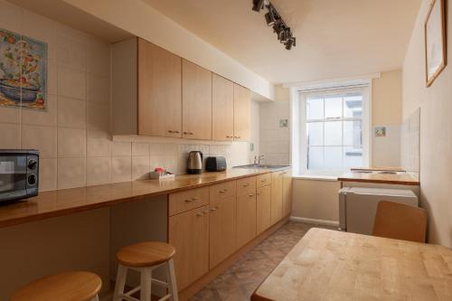 a kitchen with wooden cabinets and a table and a window at Discovery Accommodation in Whitby