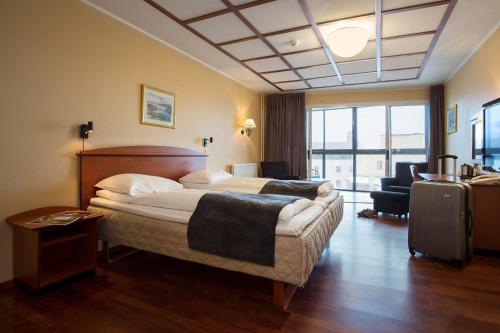 a hotel room with a bed and a living room at Scandic Harstad in Harstad