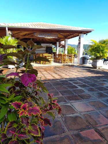 a patio with a pavilion with flowers in the foreground at Pousada irmãos Oliveira in Lindóia