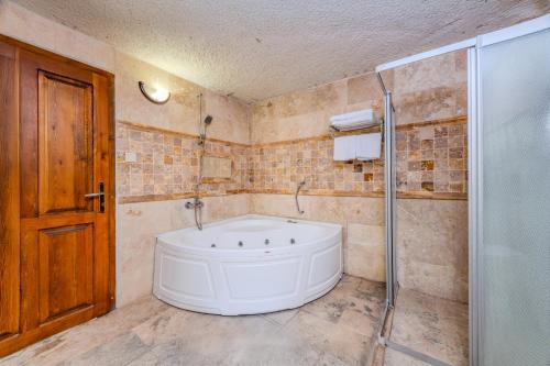 a bathroom with a large tub and a shower at Onur Cave Cappadocia in Goreme