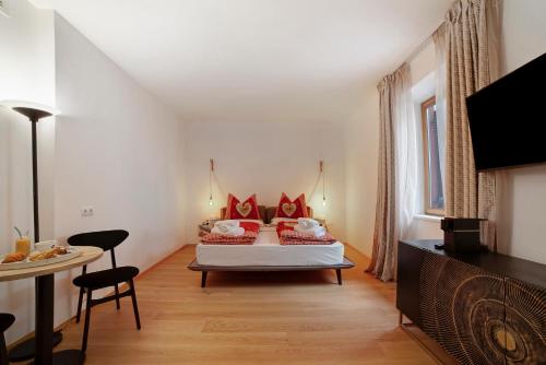 a living room with a bed and a table at Boutique Hotel Santer Klause in Merano