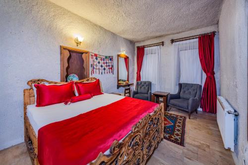 a bedroom with a large bed with red pillows at Onur Cave Cappadocia in Goreme
