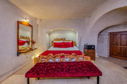 a bedroom with a large bed with red pillows at Onur Cave Cappadocia in Goreme