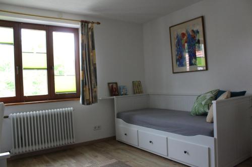 a small bedroom with a bed and a window at Hofgut Homboll in Hilzingen
