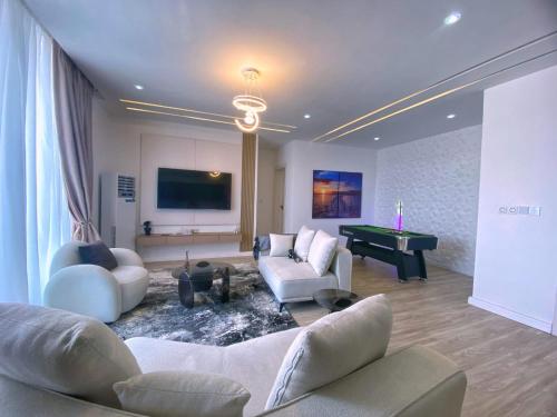 a living room with couches and a pool table at 02 cosy bedrooms appartement ikate lekki lagos in Ogoyo