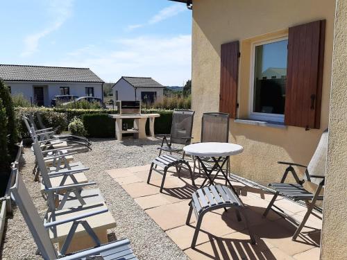 a patio with chairs and tables and a table at Modern holiday home in Aquitaine in Saint-Nexans