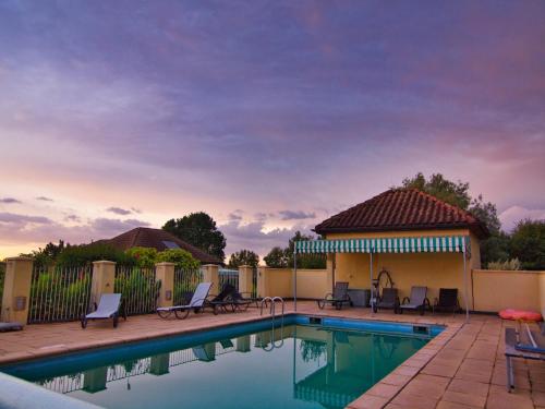 a swimming pool with chairs and a fence at Modern holiday home in Aquitaine in Saint-Nexans