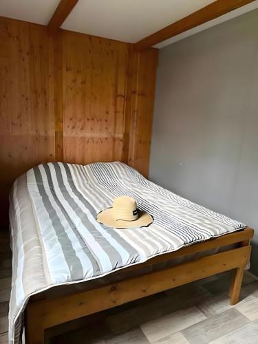 a hat sitting on top of a bed at Chalets Camping Lacs d'Armagnac in Bretagne-dʼArmagnac
