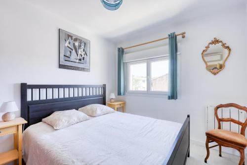 une chambre avec un lit, une chaise et une fenêtre dans l'établissement Cantourleja - apt climatisé 300m de la plage, à Six-Fours-les-Plages