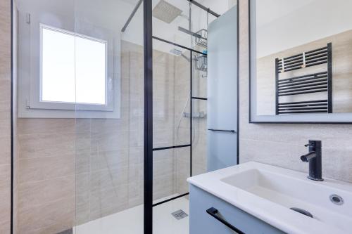 une salle de bain blanche avec un lavabo et une douche dans l'établissement Cantourleja - apt climatisé 300m de la plage, à Six-Fours-les-Plages
