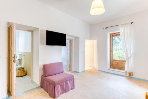 a living room with a chair and a flat screen tv at Masseria Scafazzi - Salento in Presicce