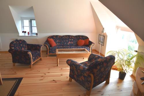 a living room with two chairs and a couch at Ferienhaus Tammwarfthuus in Pellworm